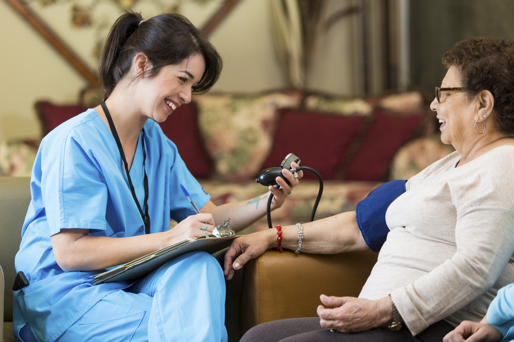 Home healthcare nurse checks patient's blood pressure